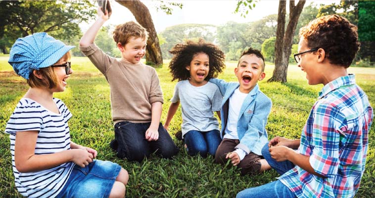 Kids sat laughing and playing together in a circle